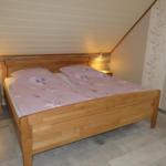 Schlafzimmer mit Holzbett, Nachttischen und gemütlicher Beleuchtung.