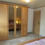 Schlafzimmer mit Holzschrank und Spiegeltüren, Tür und Wandverkleidung