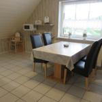 Esszimmer mit Tisch, Stühlen und Fenster. Mikrowelle und Kindersitz sind vorhanden.