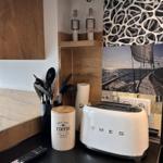 Küchenbereich mit Toaster, Kaffeetasse und Küchenutensilien.