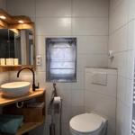 Badezimmer mit Waschtisch, Spiegel und Toilette