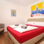 Schlafzimmer mit Bett, Sessel und Wandbildern.