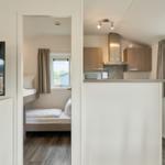 Küche mit Arbeitsplatte und Fenster. Schlafzimmer mit Bett und Fenster.