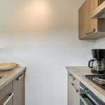 Küche mit Spüle, Kochfeld und Kaffeemaschine.