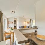 Küche mit Essbereich und Wohnzimmer im Hintergrund.