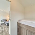 Schlafzimmer mit Doppelbett und Sicht auf Wohnbereich mit Sofa.