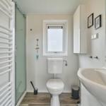 Badezimmer mit Dusche, Toilette und Waschbecken.