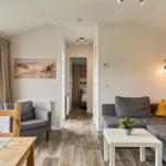 Wohn- und Essbereich mit Sofa, Tisch und Blick auf Garten