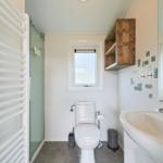 Badezimmer mit Dusche, Toilette und Waschbecken.