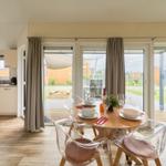 Essbereich mit Tisch und Stühlen, Blick auf Terrasse und Garten.