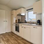 Küche mit Arbeitsplatte, Spüle, Herd und Kühlschrank.