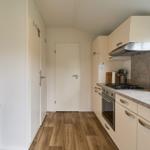 Küche mit Arbeitsplatte, Herd, Spüle und Fenster