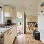 Küche mit Blick auf Terrasse und Essbereich mit Sofa und Tisch.