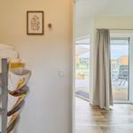 Kinderzimmer mit Doppelstockbett und Spielzeugregal. Durchgang zur Terrasse mit Blick auf Garten.