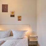 Ein Bett mit zwei Kissen und Wandbildern über dem Kopfteil.