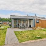 Moderne Ferienhaus mit Terrasse, Grill und Sitzgelegenheiten im Freien.