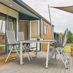 Terrasse mit Tisch, Stühlen und Sonnensegel. Holz- und Steinbelag.