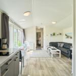 Küche mit Esstisch, Wohnbereich mit Sofa und Blick in Schlafzimmer