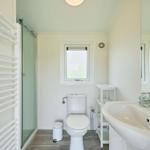 Badezimmer mit Dusche, Toilette und Waschbecken.