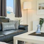 Schwarzes Sofa mit Kissen, weißer Couchtisch und Stehlampe im Wohnzimmer.