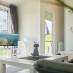 Wohnzimmer mit TV, Couch und Blick auf Garten