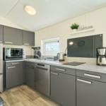 Küche mit Kühlschrank, Spülmaschine und Kochfeld.