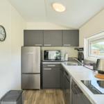 Küche mit Kühlschrank, Spüle und Kochfeld.