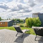 Terrasse mit zwei Liegestühlen und Blick auf moderne Häuser.