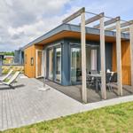 Moderne Unterkunft mit Terrasse, Sitzgelegenheiten und Gartenbereich.