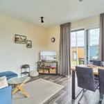 Wohn- und Essbereich mit Sofa, TV und Terrassentür.