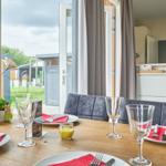 Esstisch mit Platz für vier Personen, Blick auf Garten und Terrasse.