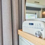 Radio auf Holzregal neben Vorhang im Wohnbereich