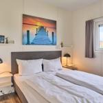 Schlafzimmer mit Doppelbett, Wandbild und Fenster mit Blick.