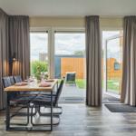 Essbereich mit Tisch und Stühlen. Durchgehendes Fenster mit Blick auf Terrasse.