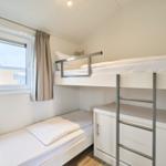 Zimmer mit Doppelstockbett, Fenster und Schrank