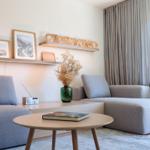 Wohnzimmer mit Sofa, Tisch und Wandregal mit Bildern und Dekoration.