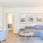 Wohnbereich mit Sofa, Tisch und Wandbildern