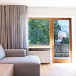 Wohnzimmer mit Sofa, Blick auf Balkon und Berge