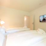Schlafzimmer mit Doppelbett, TV und integriertem Schrank