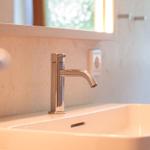 Waschbecken mit modernem Wasserhahn und Spiegelschrank