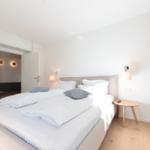 Schlafzimmer mit Doppelbett, Nachttisch und Lichtschalter