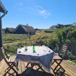 Deck with table and chairs. View of traditional houses and green areas.