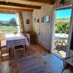 Dining room with table, chairs, and view of balcony and landscape.