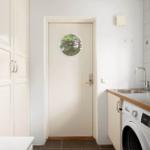 Helle Küche mit Waschmaschine und Tür mit runden Fenster