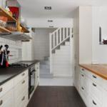 Küche mit Arbeitsplatte, Schränken und Stufen zur Treppe