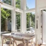 Essbereich mit Tisch und Stühlen, große Fenster, Blick auf Terrasse und Garten.