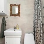 Badezimmer mit Waschbecken, Toilette und Dusche mit Vorhang.