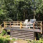 Holzterrasse mit Liegestühlen im Wald