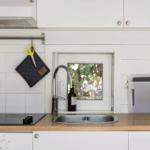 Küche mit Spüle, Herd und Fenster zum Garten