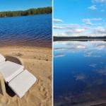 Liegendecke am Strand mit Blick auf ruhiges Wasser und Wald. Spiegelglattes Seeufer unter blauem Himmel.